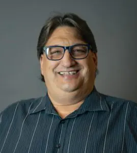 A man with glasses smiling